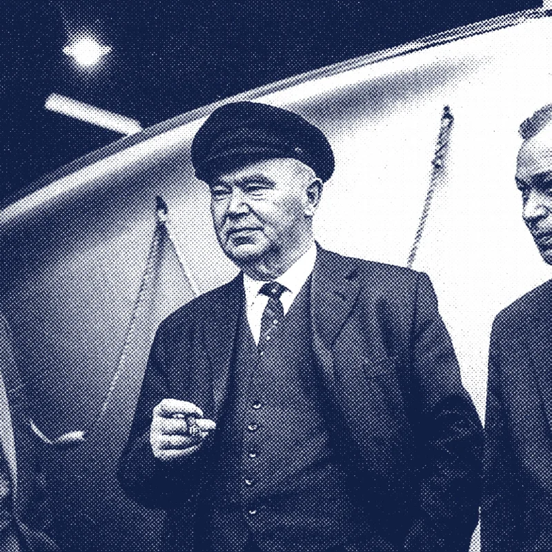 Historic photo of the Fassmer management: Heinz Fassmer, Hans Fassmer and Friedrich Fassmer in conversation in front of a boat hull. The image shows the Fassmer family generation that significantly shaped the shipyard’s post-war development.